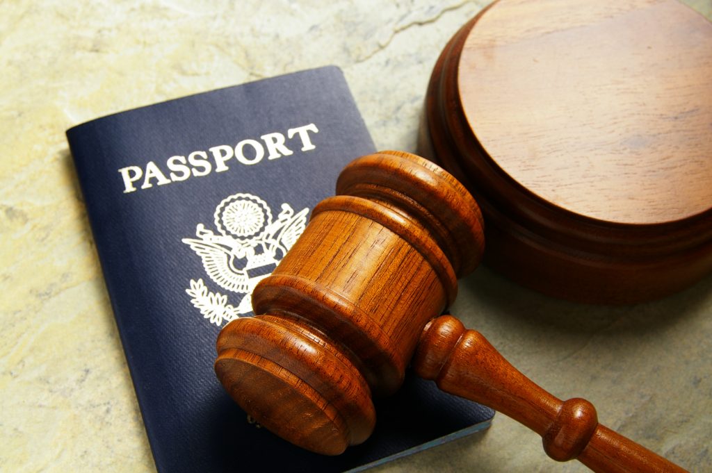 Photo of a wooden gavel on top of a passport book