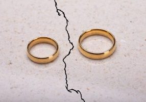 Two,Separated,Wedding,Rings,On,Cracked,Surface