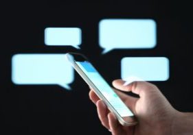 Text,Messages,In,Cellphone,Screen,With,Abstract,Hologram,Speech,Bubbles.