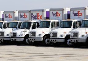 A fleet of large FedEx delivery trucks parked at a Federal Express facility at the O'Hare Airport in Chicago.