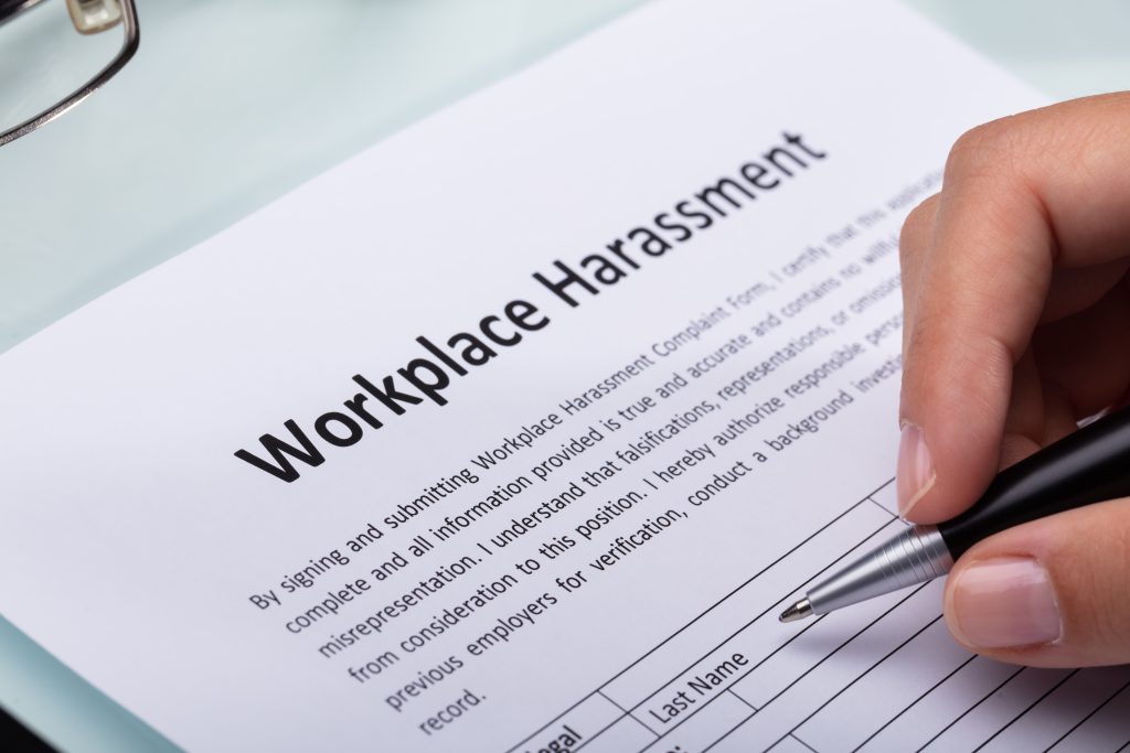 Close up of a woman's hand filling out a workplace harassment form