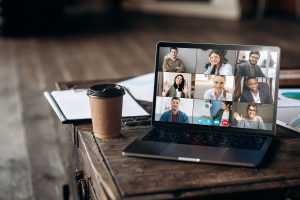 Virtual meeting online. Video conference by laptop. Online business meeting. On the laptop screen, people who gathered in a video conference to work on-line, near stands a cup of coffe