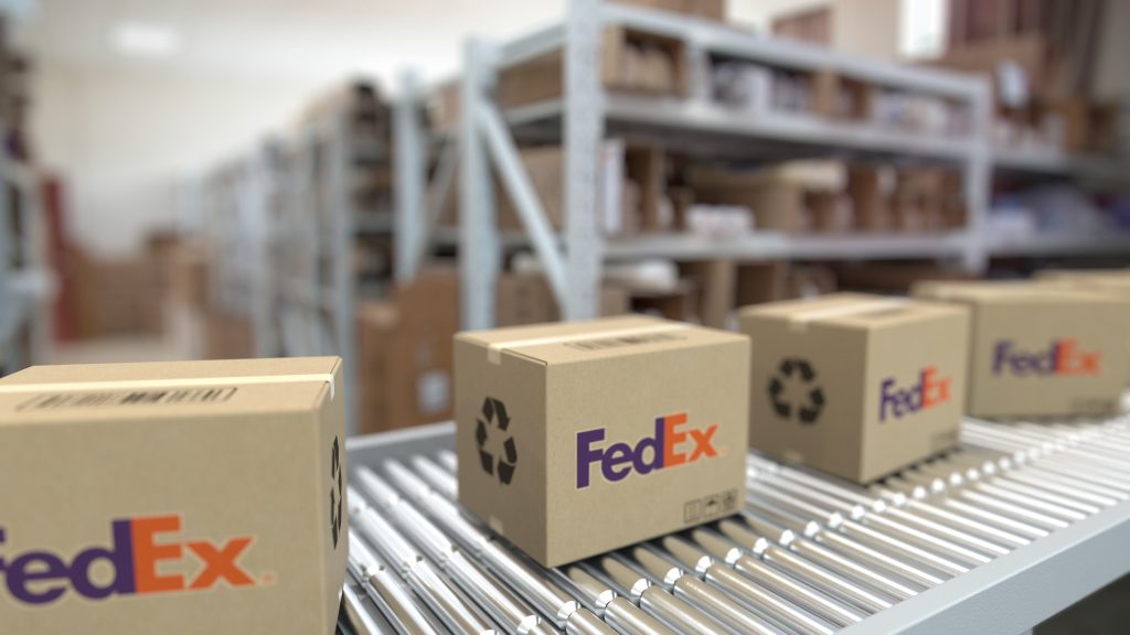 Cardboard boxes with fedex logos on a conveyor belt.
