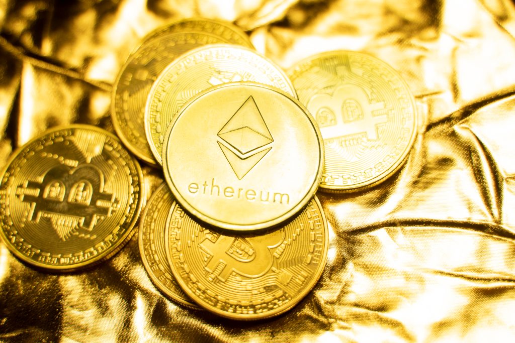 Gold Ethereum and bitcoin coins on a golden background
