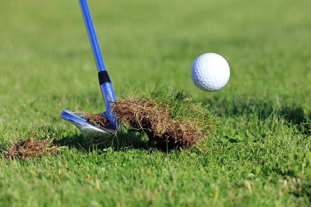Chipping Golf Ball Out Of The Rough Grass With Divot.